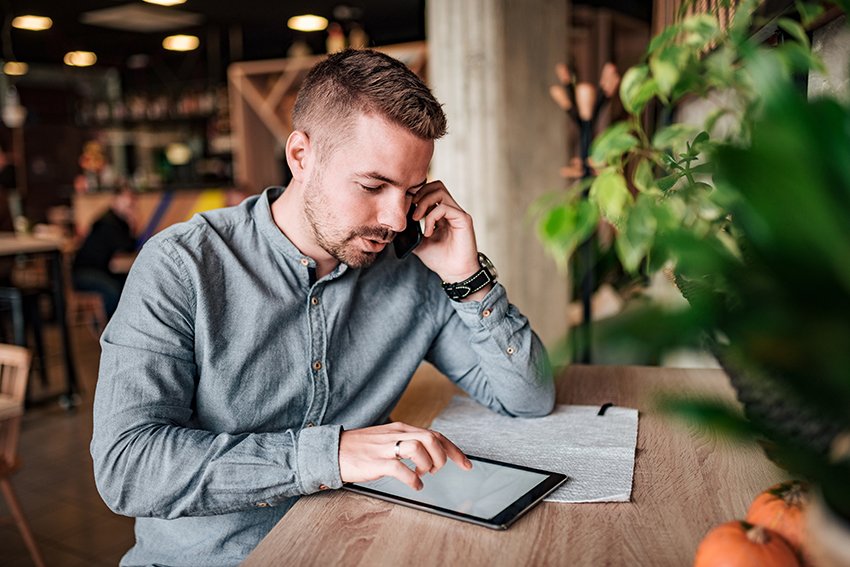 man-looking at tablet on phone