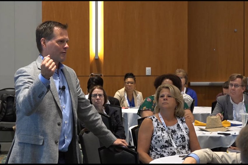 Man speaking at an event showing him in action